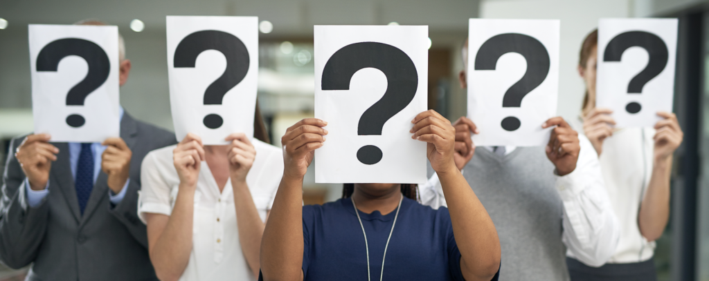 A group of people holding a paper with a question mark